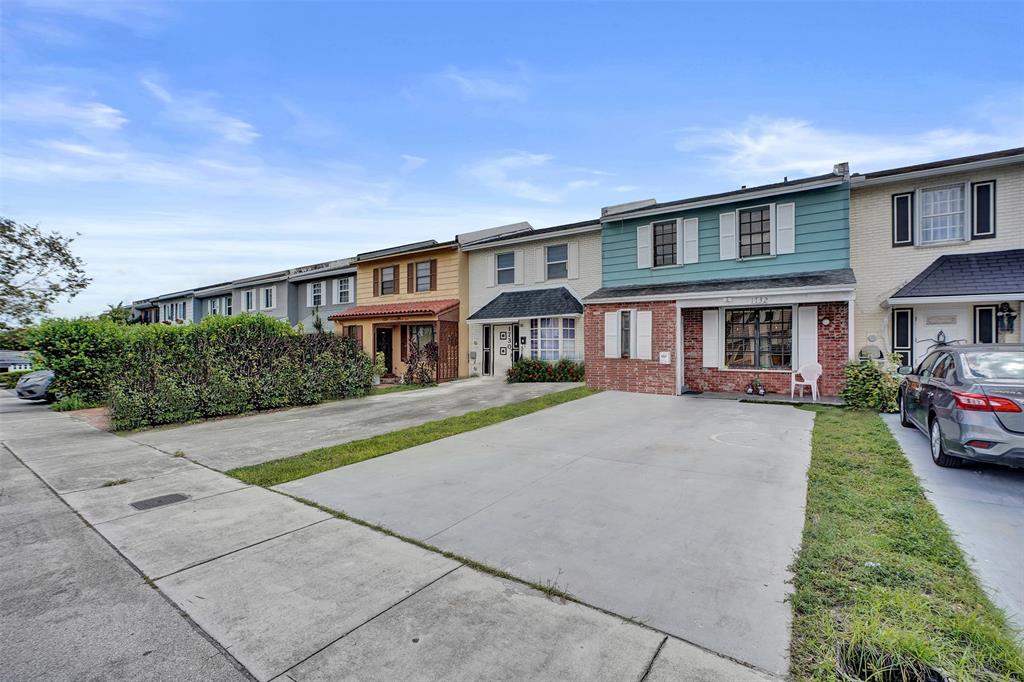 1732 West 72nd Street, Unit 1732 Hialeah, FL 33014 - Photo 3 of 58 a front view of a house with a yard and garage