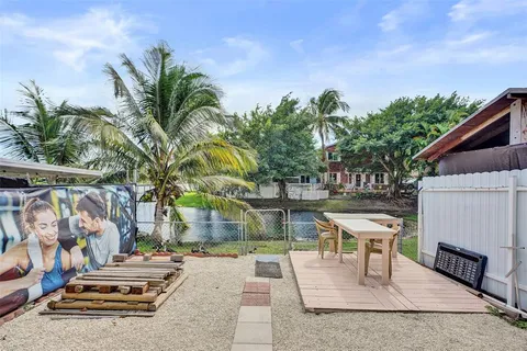 a view of a patio with table and chairs under an umbrella with wooden fence