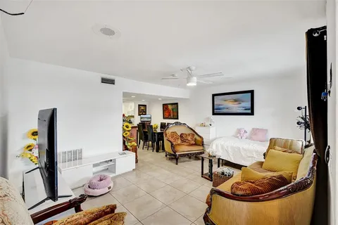 a living room with furniture a flat screen tv and a floor to ceiling window