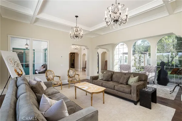 a living room with furniture a chandelier and a large window