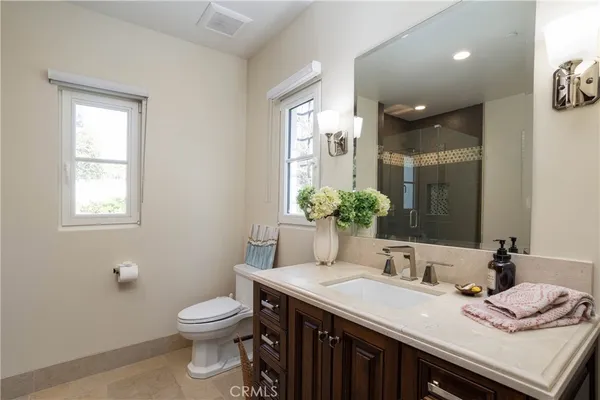 a bathroom with a granite countertop sink a toilet and a mirror