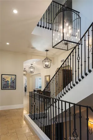 a view of staircase with railing and a chandelier