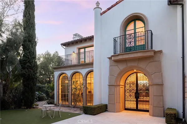 a view of a brick house with large windows and a clock tower in the middle