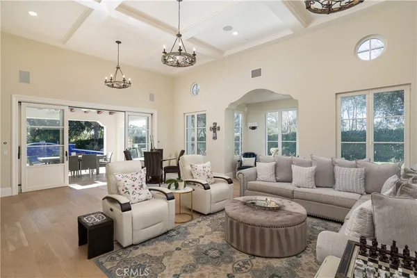 a living room with furniture a chandelier and a large window