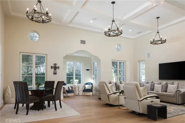 a living room with furniture chandelier and a flat screen tv