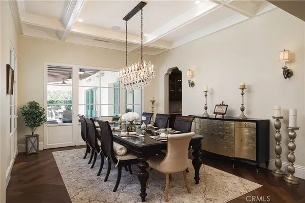 a dining room with furniture a chandelier and wooden floor