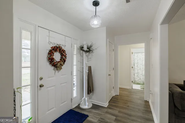 a hallway with wooden floor and couches