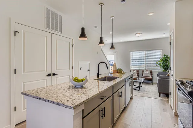 a kitchen with sink a stove and chairs