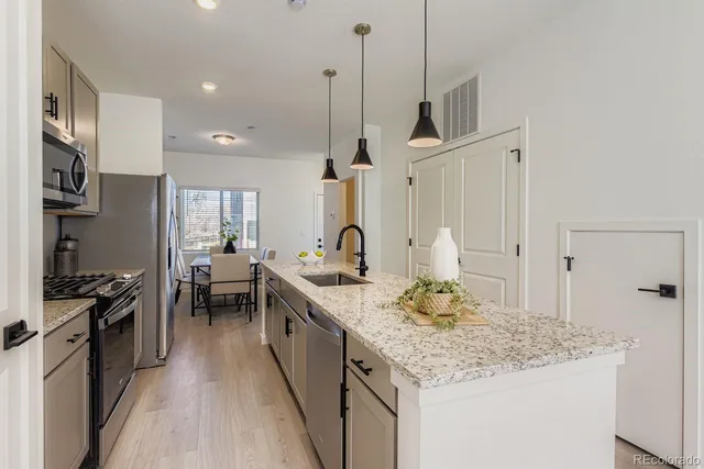 a kitchen with stainless steel appliances granite countertop a sink stove and refrigerator