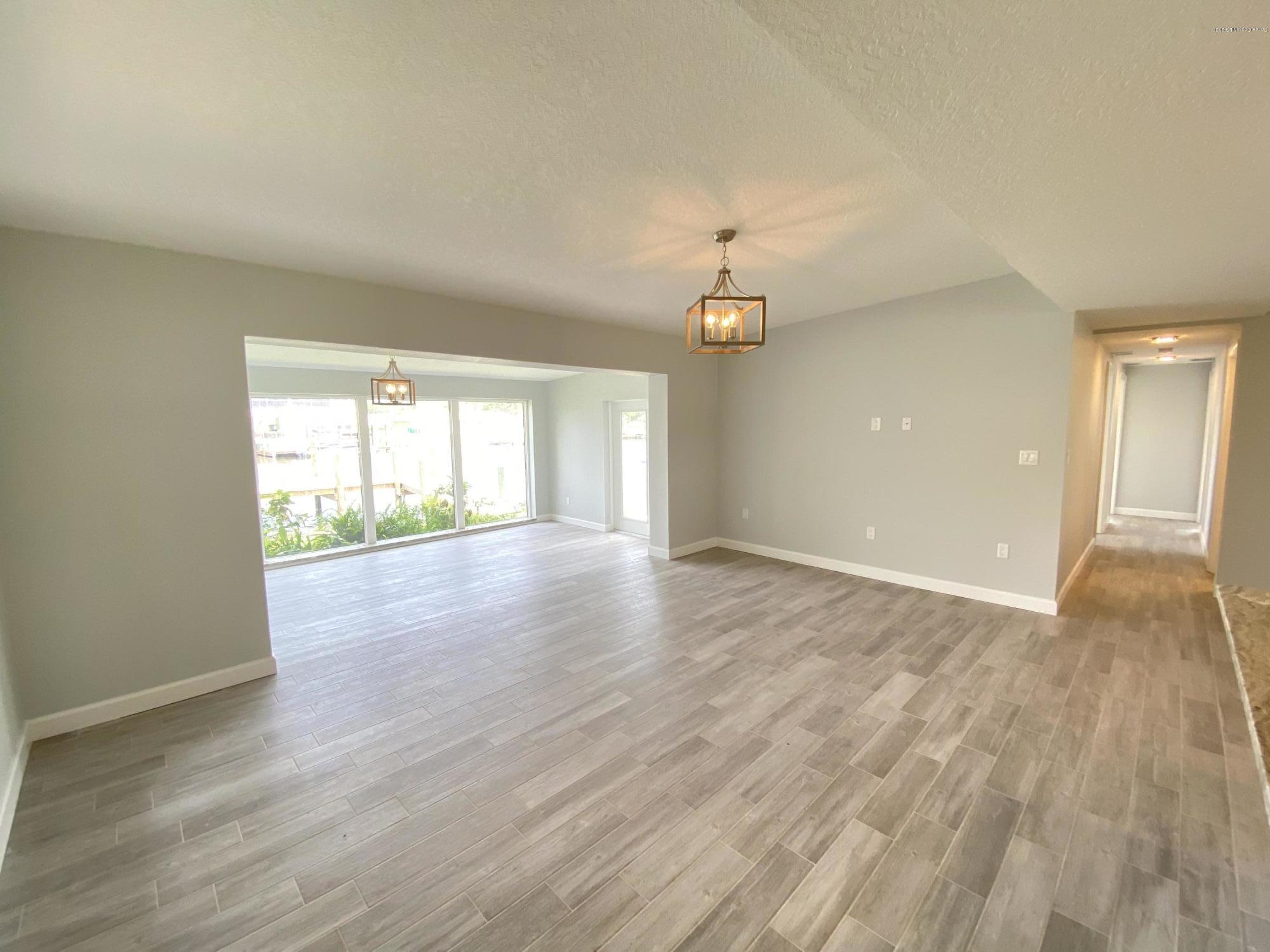 367 Capri Road Cocoa Beach, FL 32931 - Photo 10 of 27 a view of an empty room with wooden floor and a window