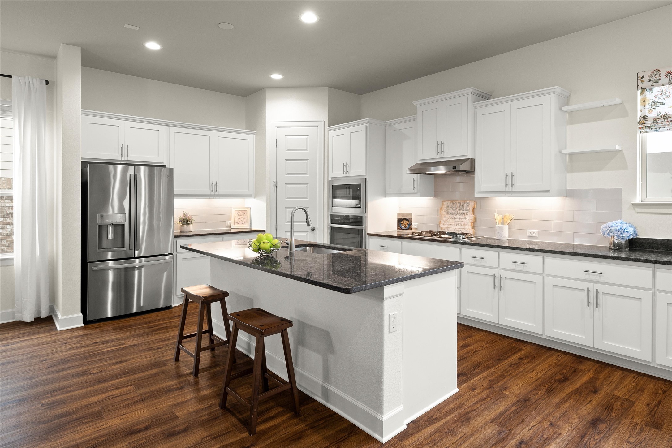 143 Bright Vly Way Austin, TX 78737 - Photo 15 of 34 a kitchen with granite countertop white cabinets refrigerator and chairs