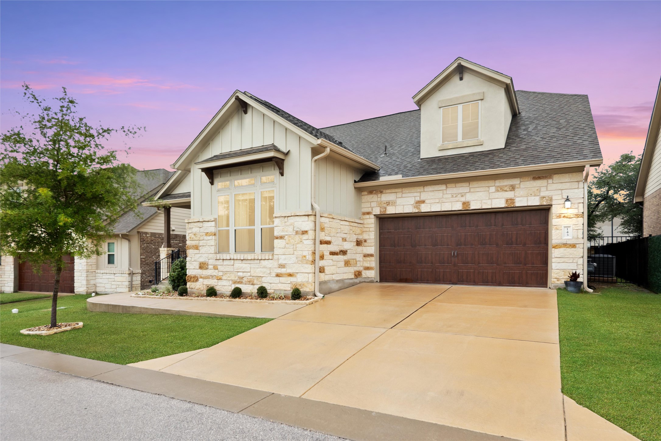 143 Bright Vly Way Austin, TX 78737 - Photo 2 of 34 a front view of a house with a yard and garage