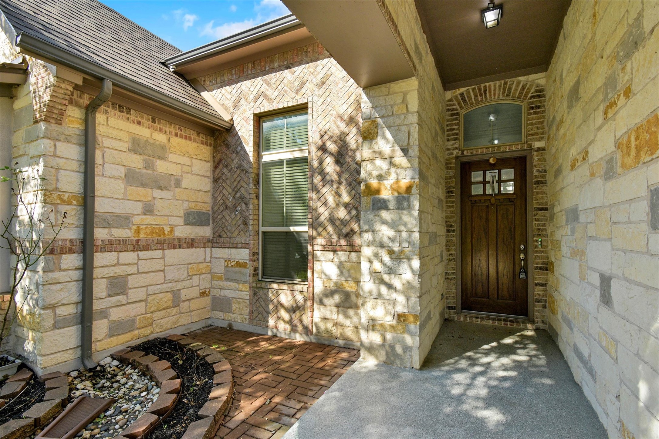 2325 Blended Tree Ranch Drive Leander, TX 78641 - Photo 5 of 35 A welcoming entry featuring varied stone and brick patterns, leading to a paneled wood door.
