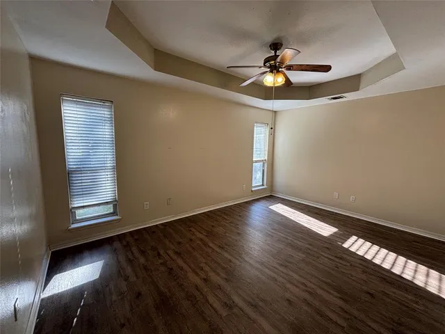 a view of a livingroom with wooden floor and a ceiling fan