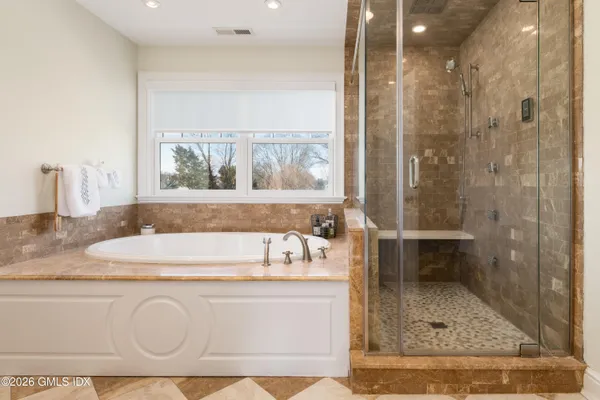 a bathroom with a granite countertop sink a mirror and a bathtub