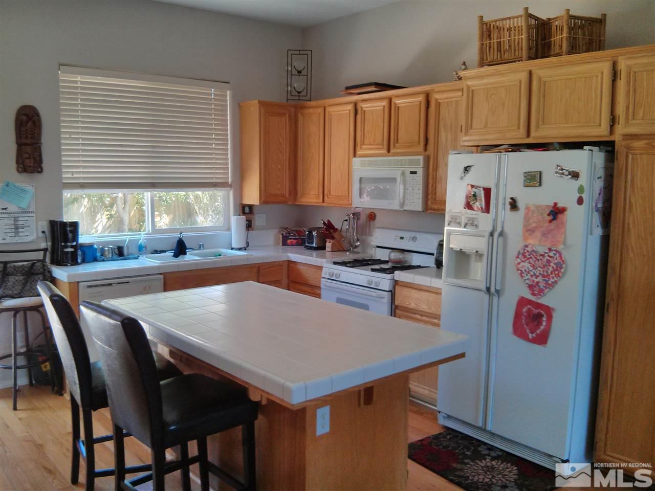 1641 Brentworth Way Reno, NV 89521 - Photo 6 of 11 a kitchen with a refrigerator a stove a sink dishwasher and a refrigerator with wooden cabinets