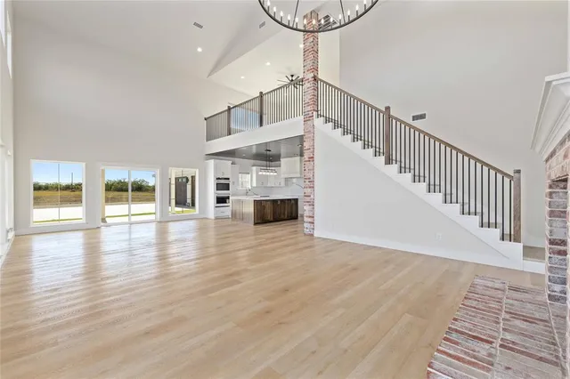 a view of a livingroom with wooden floor and staircase