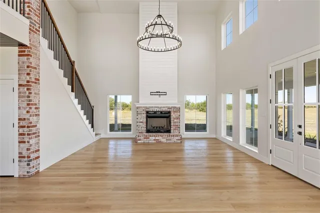 a view of a livingroom with wooden floor fireplace and windows