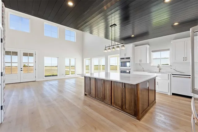 a kitchen with stainless steel appliances granite countertop a lot of counter space and wooden floors