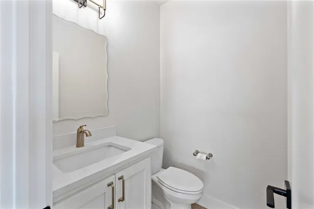 a bathroom with a sink a toilet and a mirror