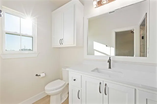 a bathroom with a sink toilet and window
