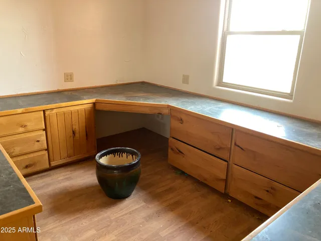 a view of a hallway to room with wooden floor