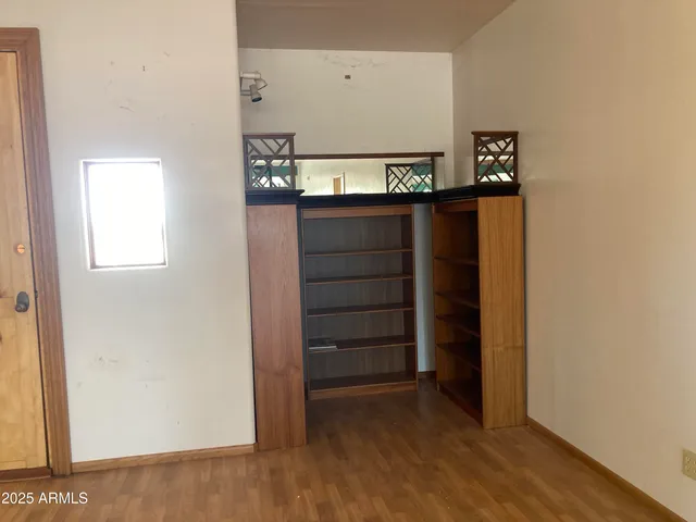 an empty room with a ceiling fan and window