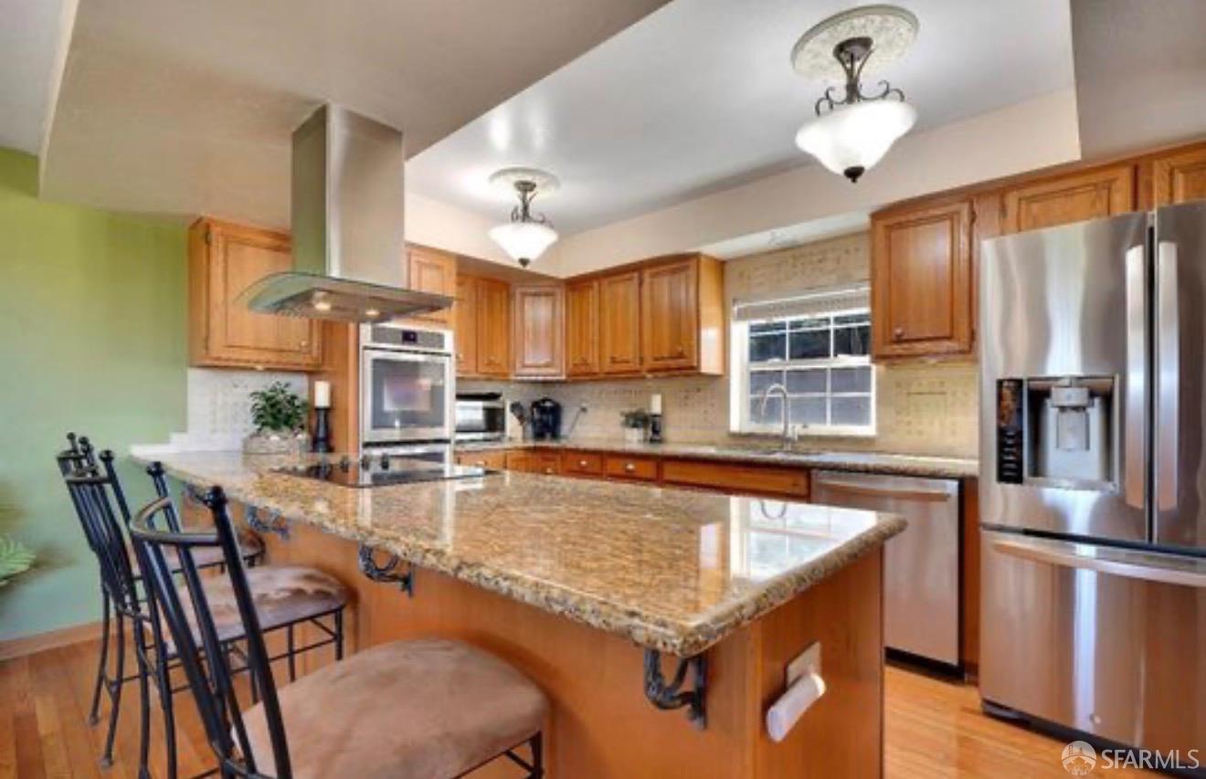4100 Gateway Road Bethel Island, CA 94511 - Photo 15 of 53 a kitchen with stainless steel appliances granite countertop a stove refrigerator a sink dishwasher a dining table and chairs with wooden floor