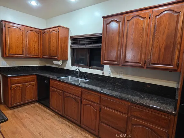 a kitchen with stainless steel appliances granite countertop a sink a stove a microwave cabinets and a counter space