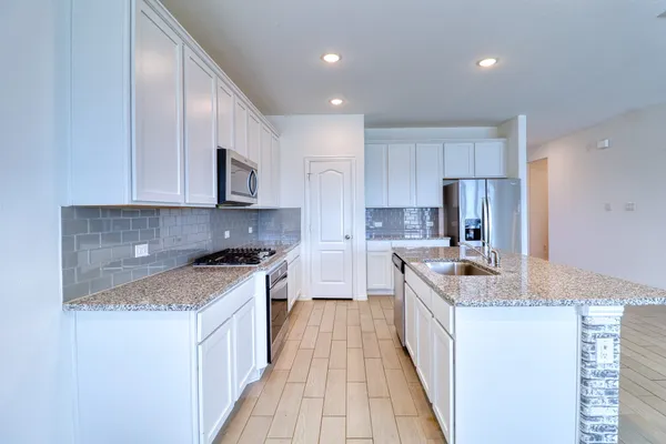 a bathroom with a granite countertop bathtub shower sink vanity and toilet