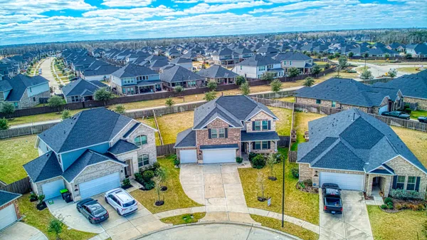 a aerial view of a house with swimming pool and large trees