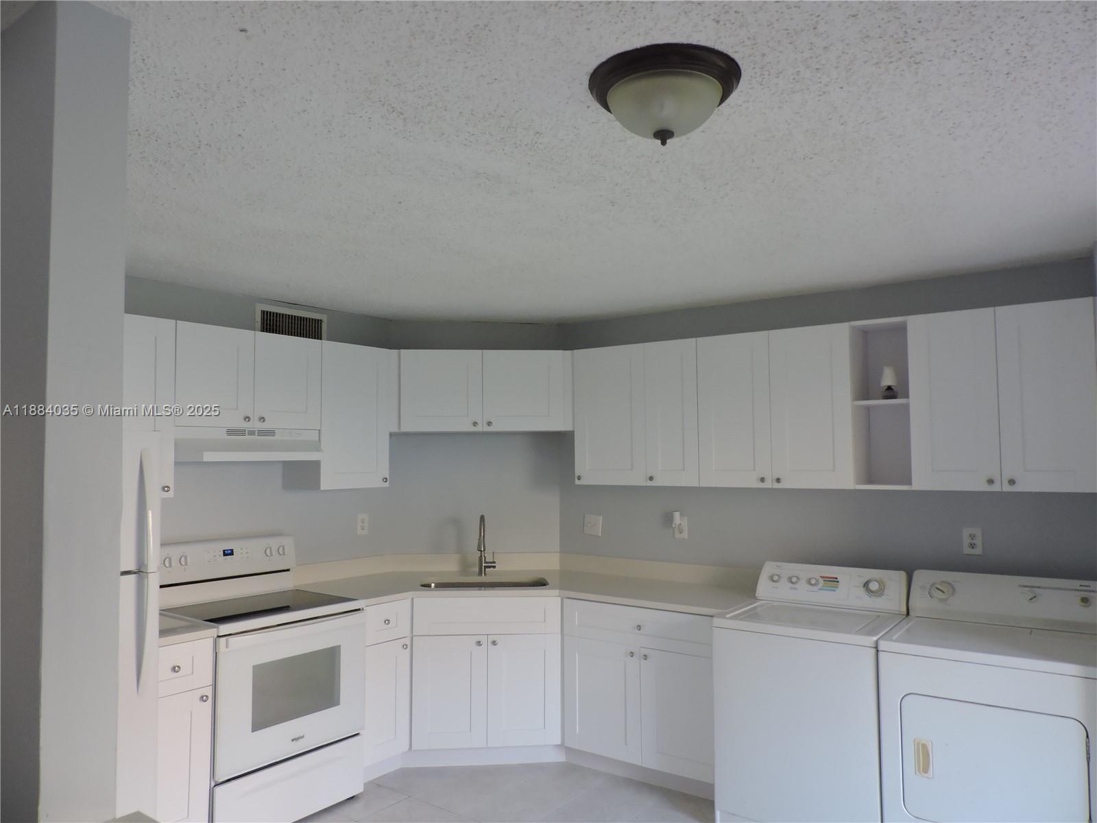 13045 Southwest 68th Street, Unit 104 Miami, FL 33183 - Photo 12 of 16 a kitchen with a sink stove and cabinets