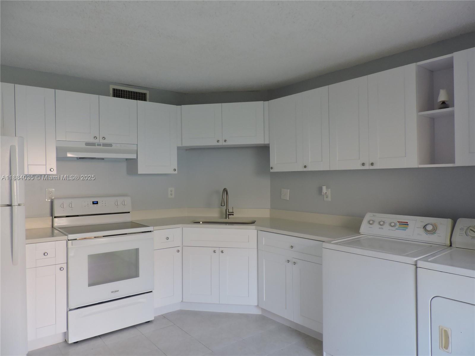 13045 Southwest 68th Street, Unit 104 Miami, FL 33183 - Photo 13 of 16 a kitchen with cabinets appliances a sink and a counter top