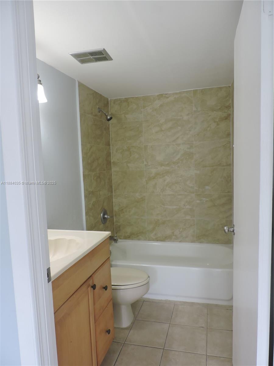 13045 Southwest 68th Street, Unit 104 Miami, FL 33183 - Photo 5 of 16 a bathroom with a sink a toilet and shower