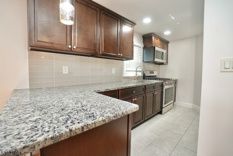 207 Franklin Avenue Belleville, NJ 07109 - Photo 2 of 9 a kitchen with stainless steel appliances granite countertop a sink stove and cabinets