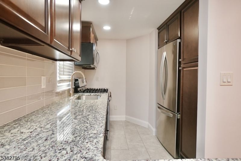 207 Franklin Avenue Belleville, NJ 07109 - Photo 3 of 9 a kitchen with stainless steel appliances granite countertop a refrigerator and a sink