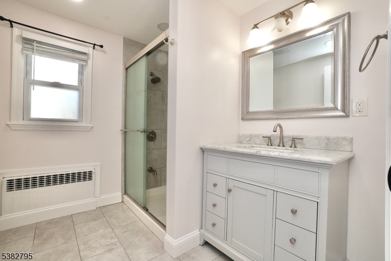 207 Franklin Avenue Belleville, NJ 07109 - Photo 6 of 9 a bathroom with a sink a vanity a window and a mirror