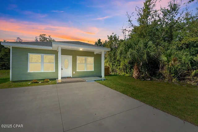a view of an house with backyard space and balcony