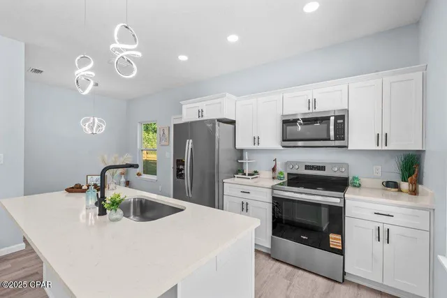 a kitchen with appliances a sink cabinets and a counter top space