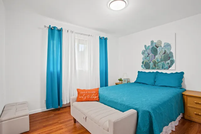 a bedroom with a bed and a painting on the wall