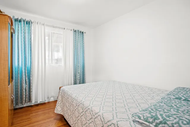 a view of a bedroom with wooden floor and a window