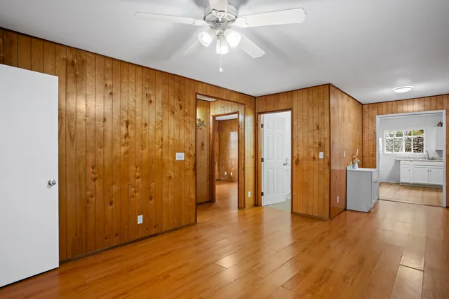 a view of an empty room with window and wooden floor