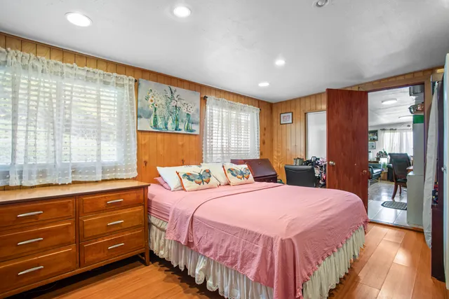 a bedroom with a bed and large windows