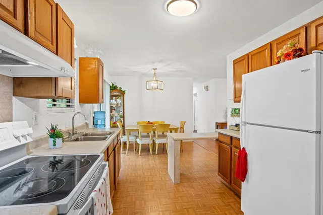 a kitchen with stainless steel appliances granite countertop a sink a stove and a refrigerator