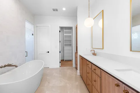 a large bathroom with a tub sink and mirror