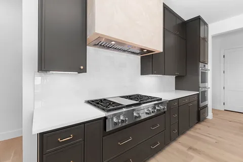 a kitchen with stainless steel appliances granite countertop a sink a stove and a refrigerator