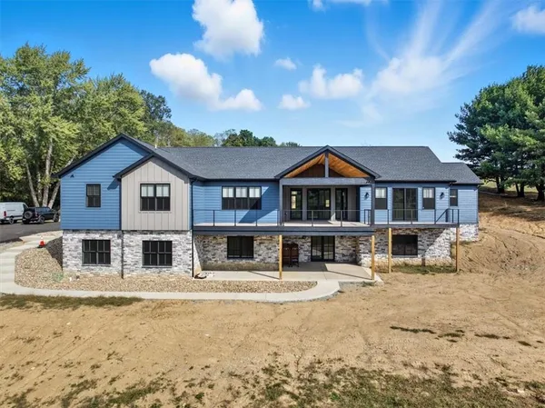 a front view of a house with a yard and covered with snow