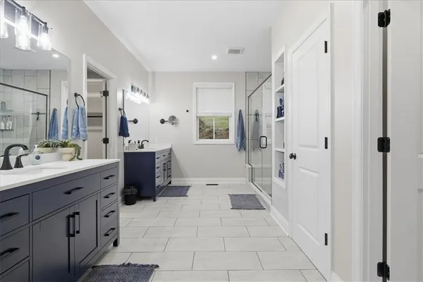 a bathroom with a sink a toilet a mirror and shower