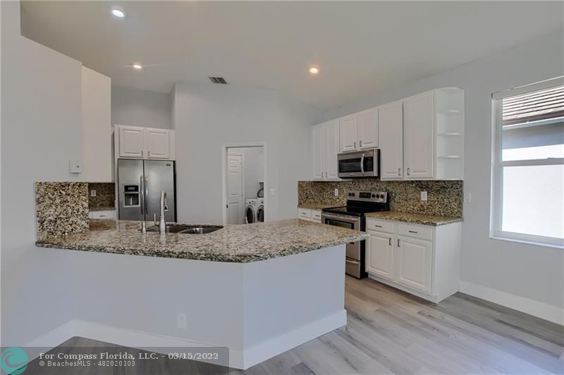 Boca Falls Boca Raton, FL 33428 - Photo 17 of 40 a kitchen with stainless steel appliances granite countertop a sink stove and microwave