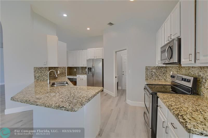 Boca Falls Boca Raton, FL 33428 - Photo 18 of 40 a kitchen with stainless steel appliances granite countertop a sink stove and refrigerator
